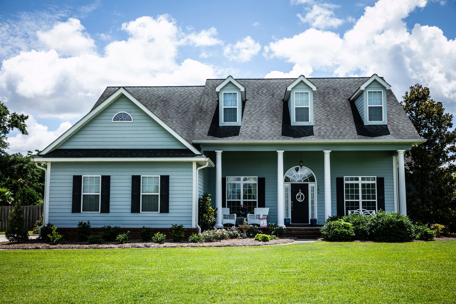 Front View of blue house with siding in the suburbs